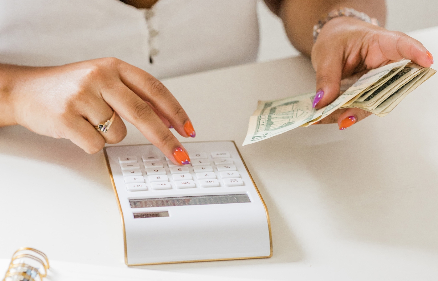 woman types numbers into calculator while learning the answer to Are Therapy Expenses Tax Deductible at therapy findr